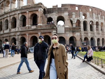 Люди в защитных масках около Колизея в Риме. Фото: Remo Casilli / Reuters